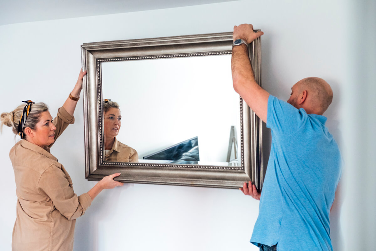 Hang frame 2 people Couple haning a framed mirror